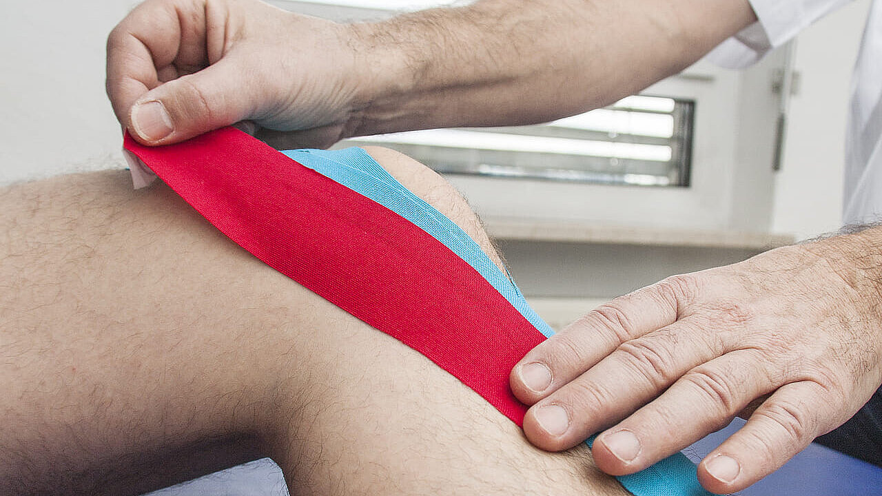 Knie wird mit Kinesio Tape behandelt